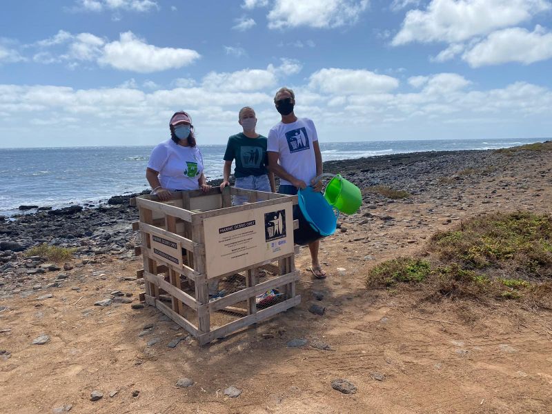 Ayto de Antigua-concejal junto a voluntarios en los pallets de retirada de residuos marinos